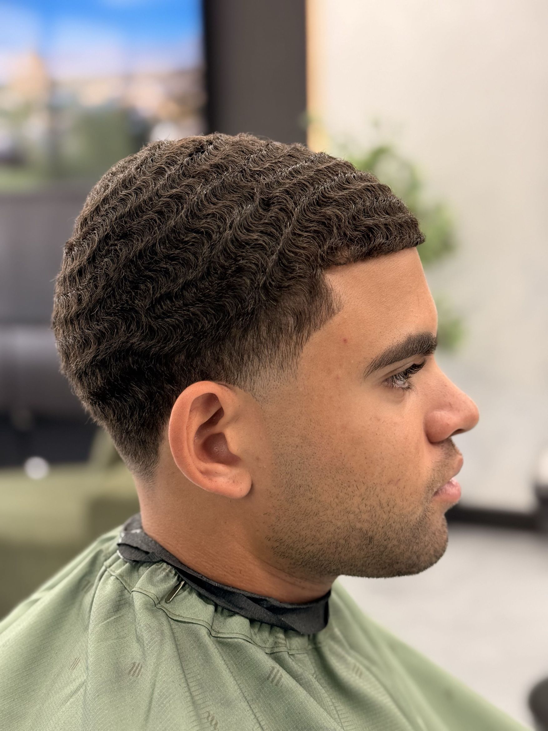A textured haircut with a clean taper at Velmor
